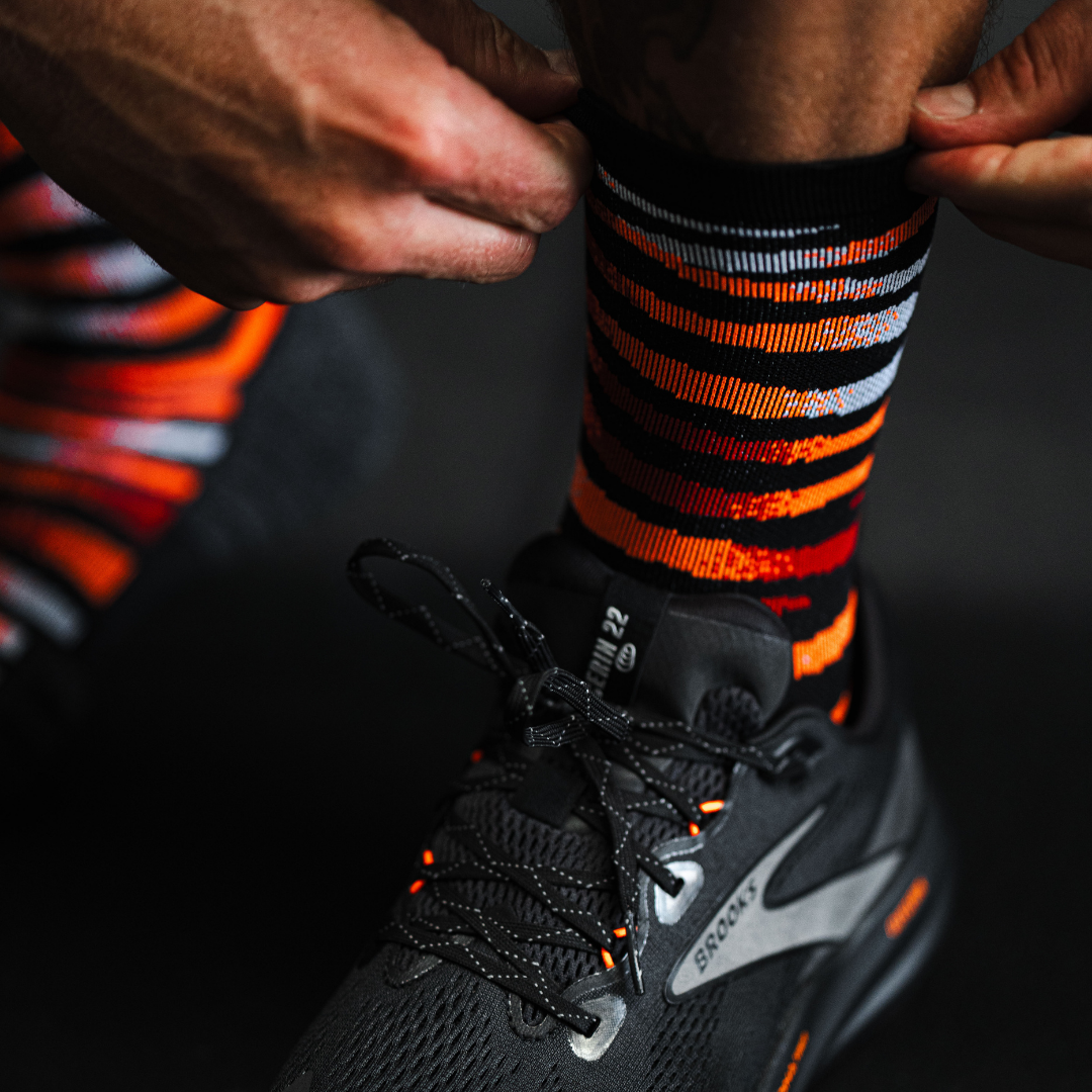 Image of person wearing Lightfeet Performance Predator Black Red Orange Half Crew Socks