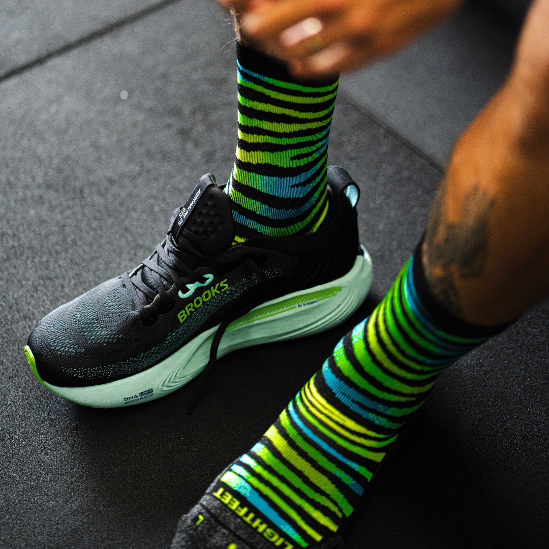 Image of person wearing Lightfeet Performance Predator Black Yellow Aqua Half Crew Sock