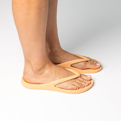 Person walking on and off screen wearing Peach Lightfeet Arch Support Thongs