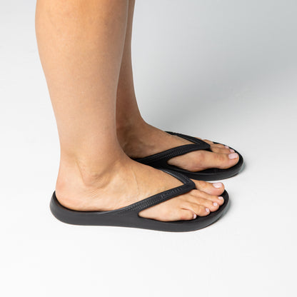 Person walking on and off screen wearing Black Lightfeet Arch Support Thongs